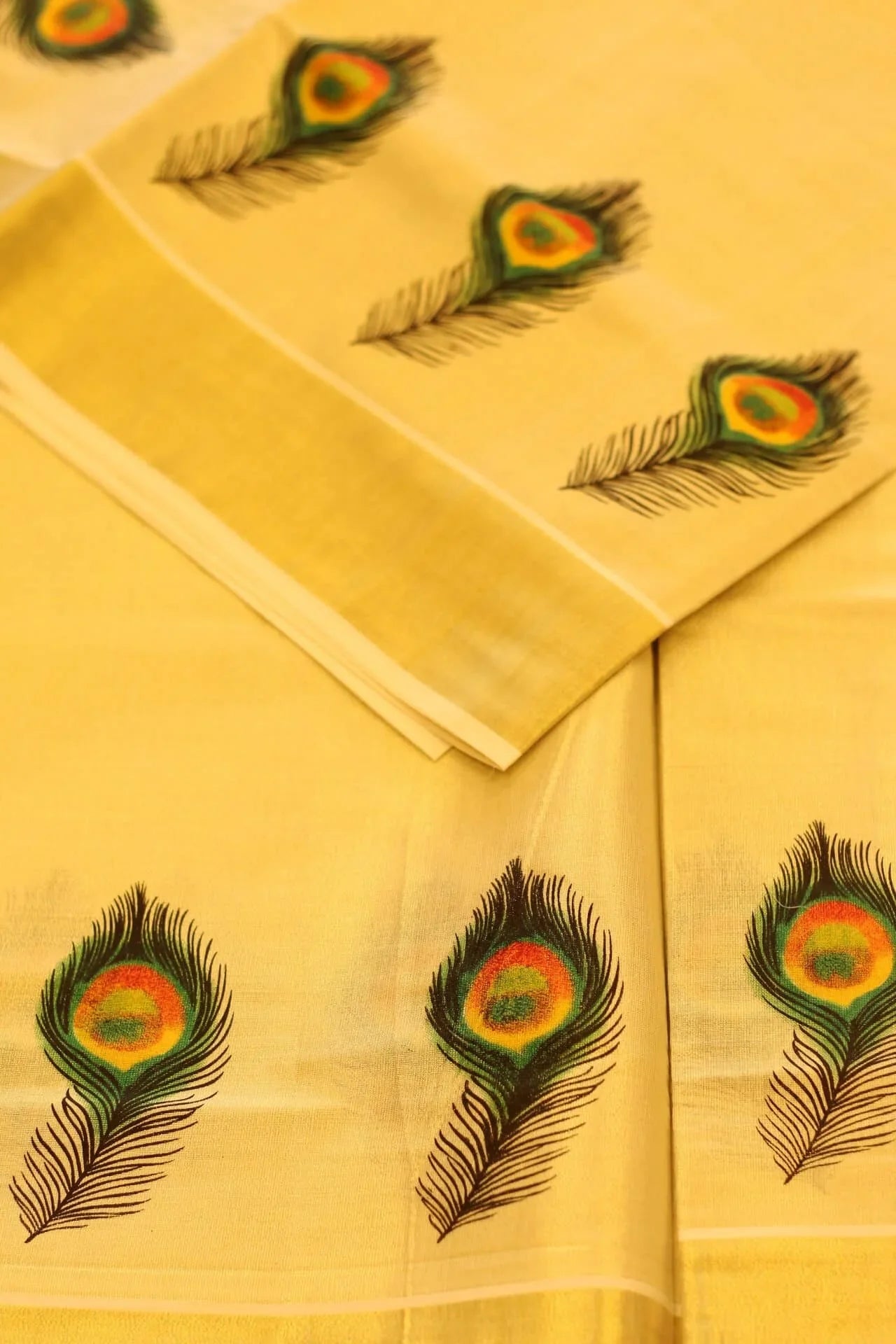 Onam saree with gold border and peacock feather design