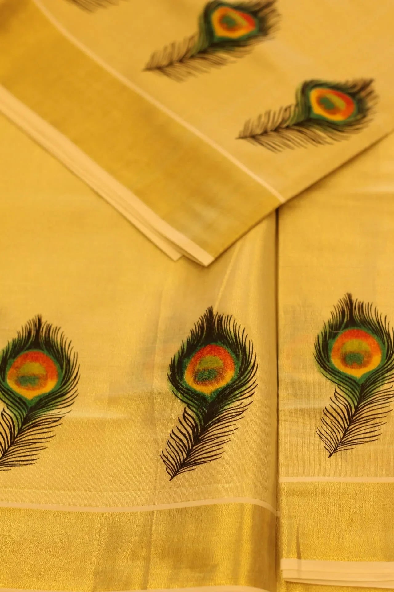 Onam saree with gold border and peacock feather design