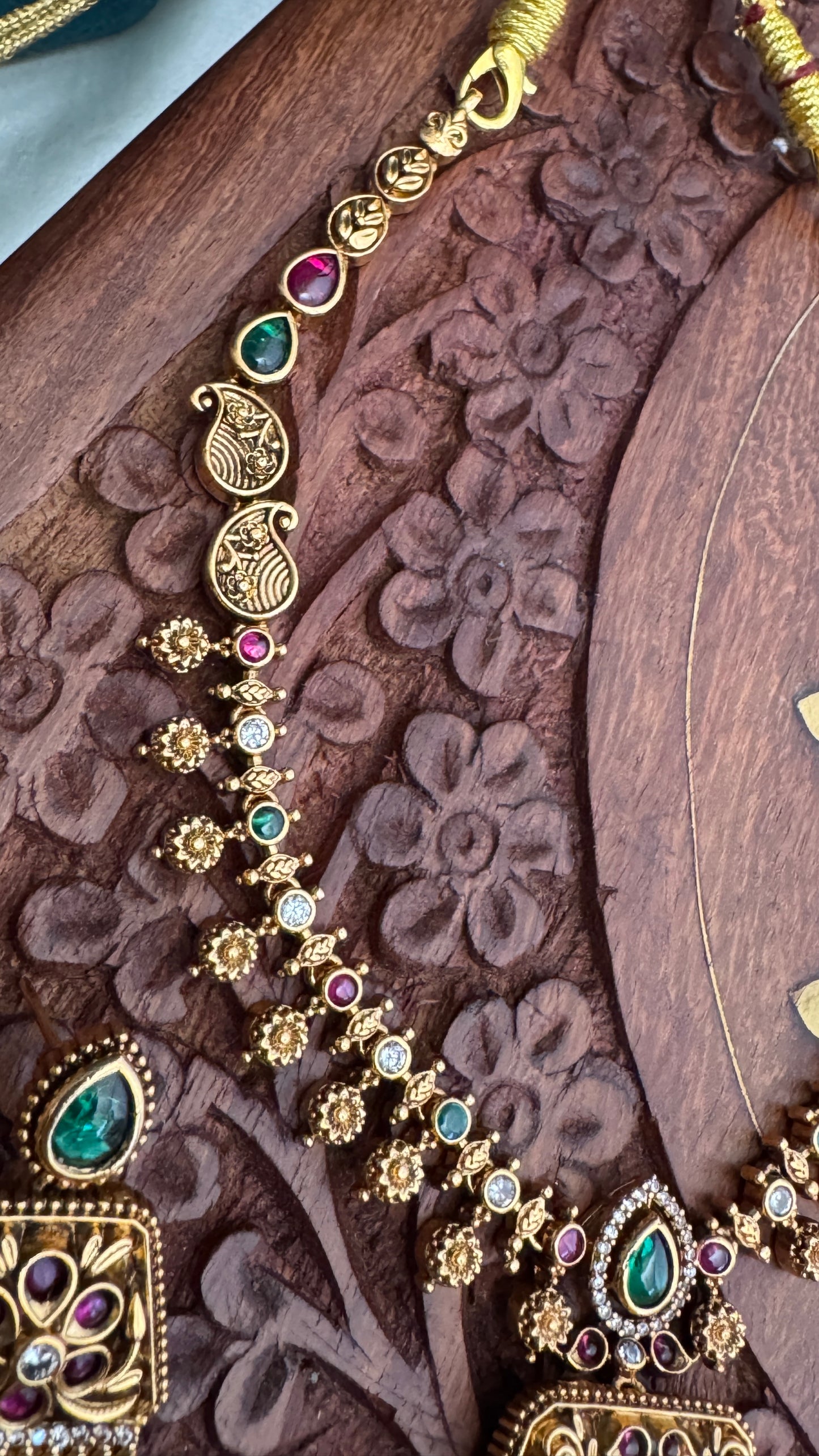 Necklace set with emerald, ruby and white color stone details.