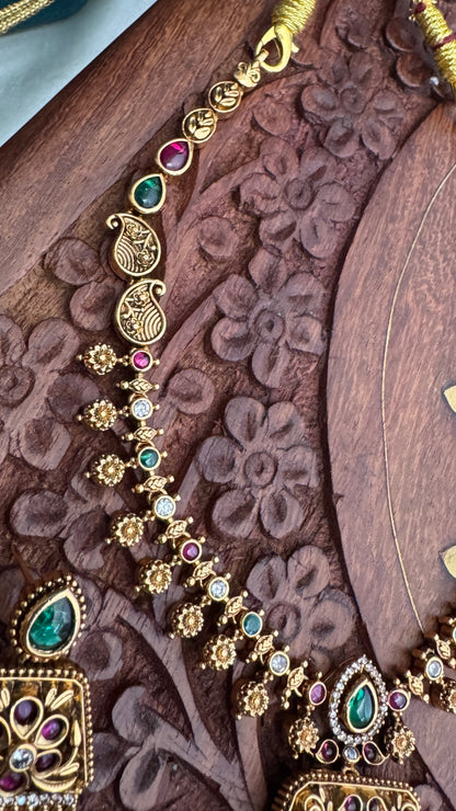 Necklace set with emerald, ruby and white color stone details.