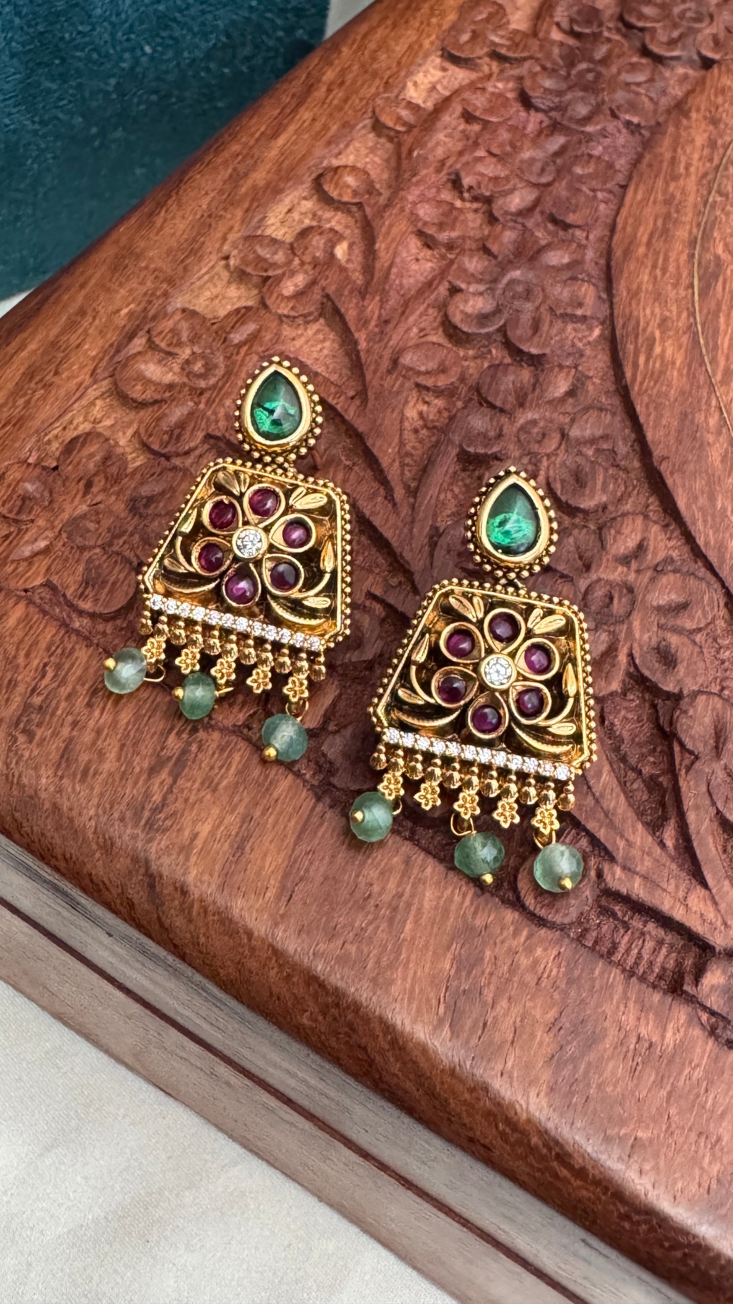 Necklace set with emerald, ruby and white color stone details.