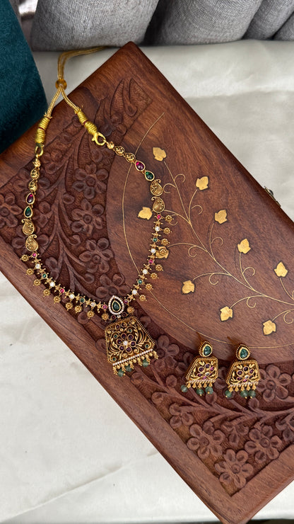Necklace set with emerald, ruby and white color stone details.