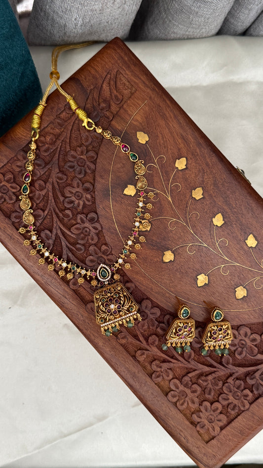 Necklace set with emerald, ruby and white color stone details.