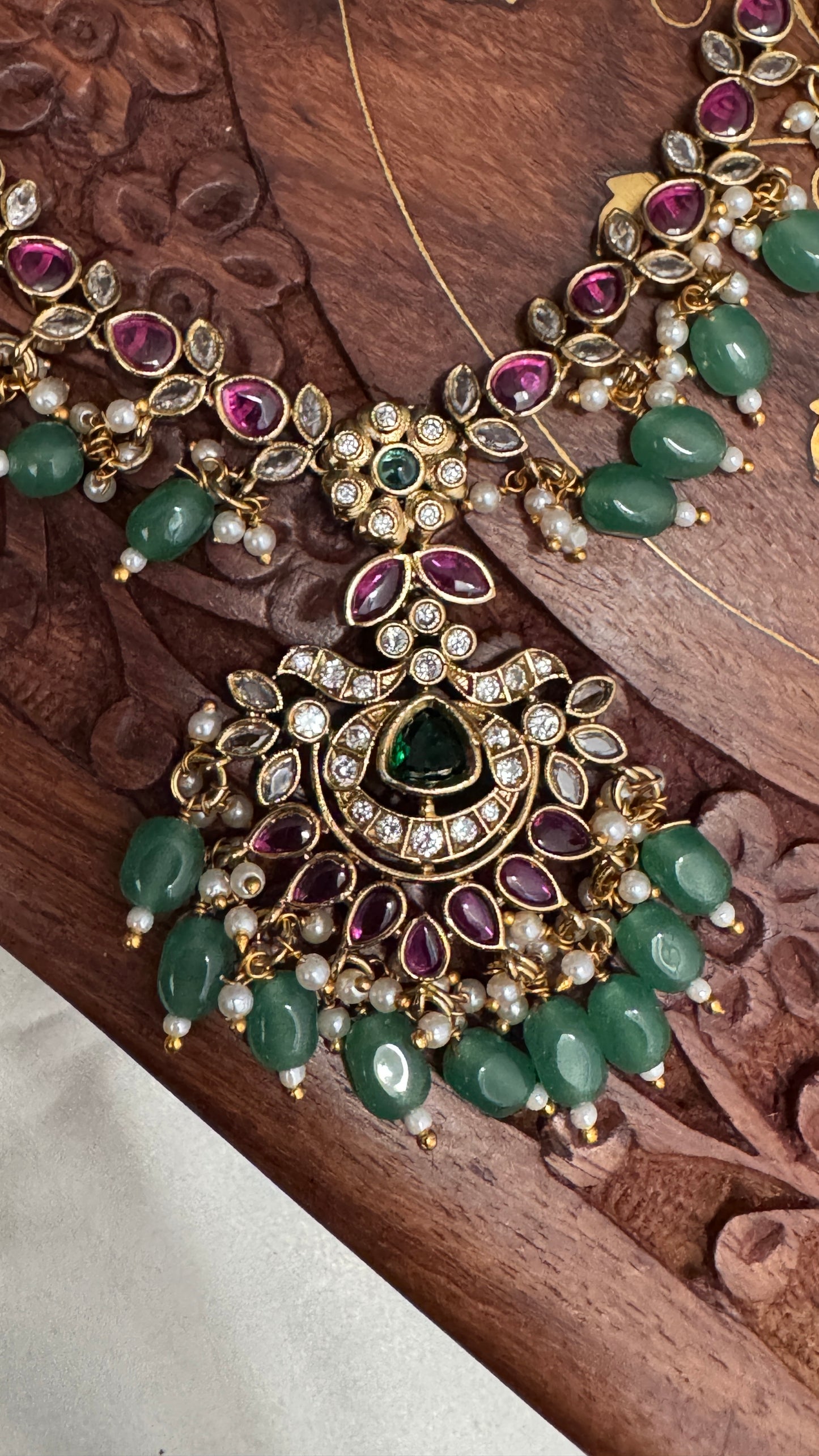 Temple Jewellery with emerald, ruby and white color stone details.