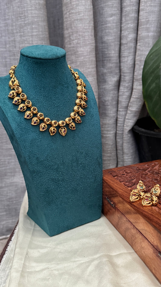 Temple Jewellery with emerald, ruby and white color stone details.